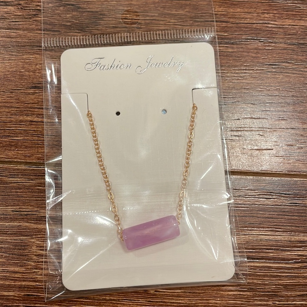 This is a purple crystal necklace with a golden chain